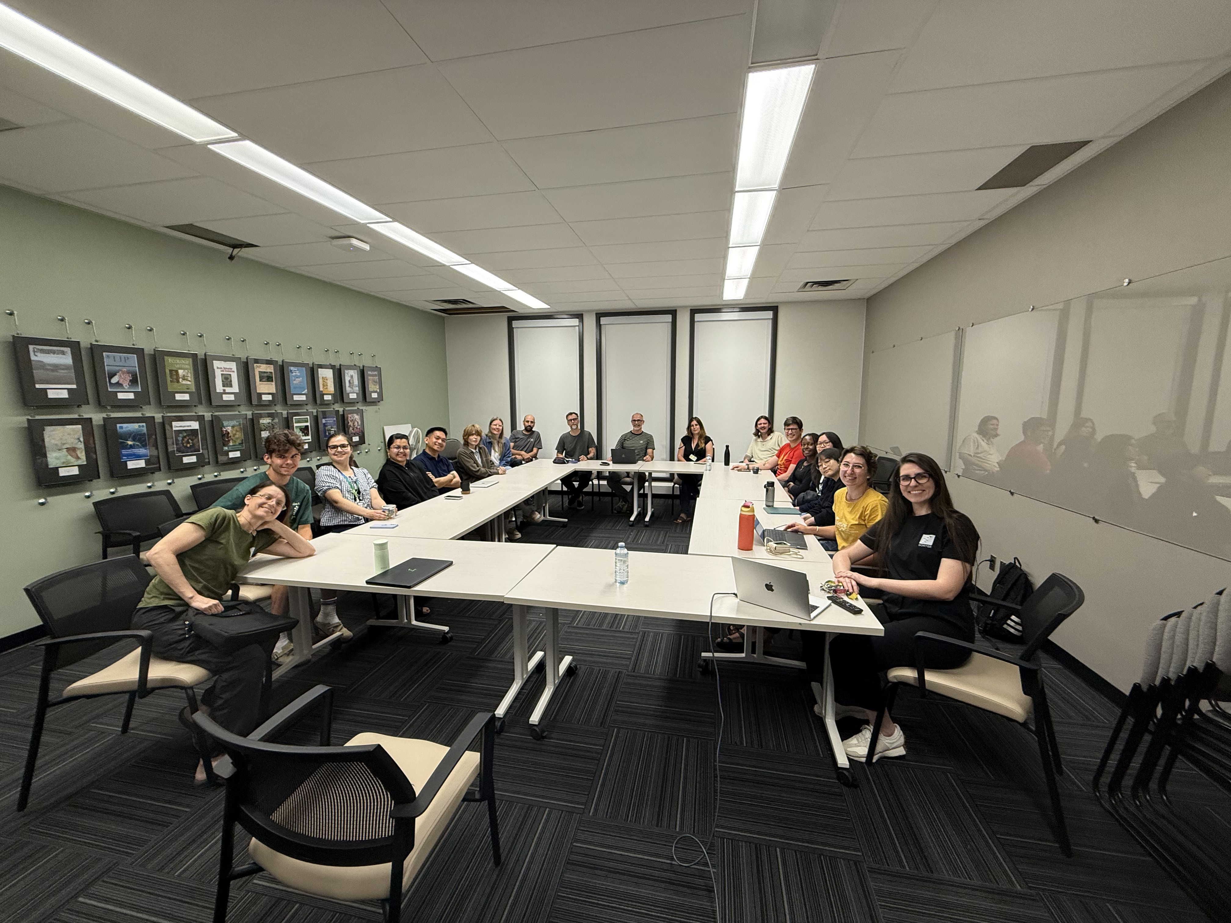 People in a meeting room at the University of Alberta, smiling and looking at the camera